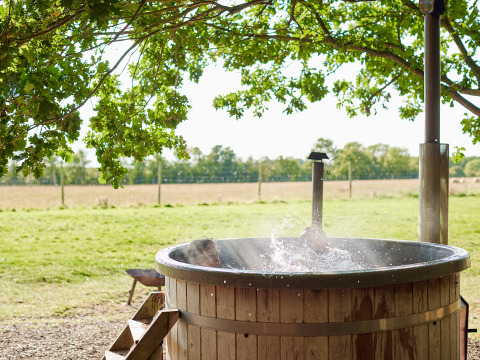 Bañera caliente de madera al aire libre en BoerenBed Layer Marney Tower, parque vacacional en este de Inglaterra.