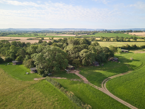 Luftfoto af BoerenBed Moor Farm feriested i det sydvestlige England med grønne marker og træhytter.