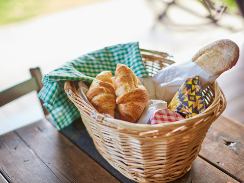 Panier avec croissants, baguette et confiture sur une table en bois à BoerenBed Moor Farm, sud-ouest Angleterre.