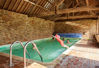 Piscina coperta presso BoerenBed Moor Farm nel sud-ovest dell’Inghilterra, bambini che giocano e saltano.