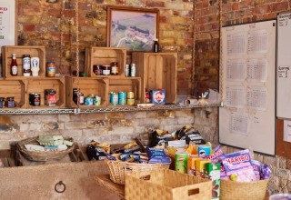Dispensa rustica a BoerenBed Moor Farm, sud-ovest dell’Inghilterra, con scaffali di snack e generi alimentari.