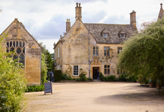 Vista de una histórica casa de piedra en BoerenBed Hidcote Manor Farm, parque vacacional en West Midlands, Reino Unido.