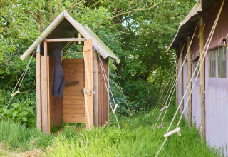 Buitendouche van hout bij BoerenBed Hidcote Manor Farm in West Midlands, omringd door groen.
