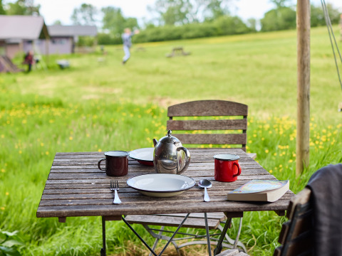 Buitentafel met servies, mokken en theepot bij BoerenBed Hidcote Manor Farm in West Midlands, Verenigd Koninkrijk.