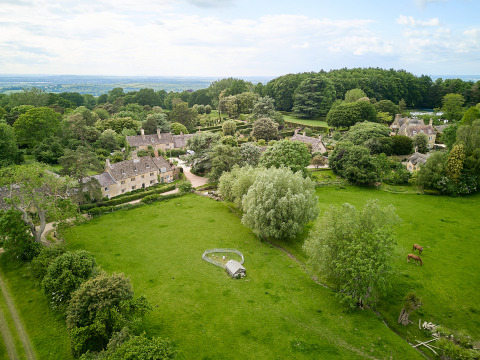 Luchtfoto van BoerenBed Hidcote Manor Farm, een vakantiepark in West Midlands, Verenigd Koninkrijk, omringd door groen.