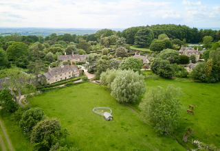 Luchtfoto van BoerenBed Hidcote Manor Farm, een vakantiepark in West Midlands, Verenigd Koninkrijk, omringd door groen.