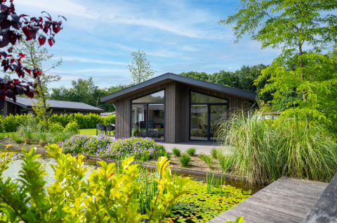 Moderne Lodge Villa Waterzicht Luxe mit großer Fensterfront, Terrasse und Blick auf Teich und Pflanzen