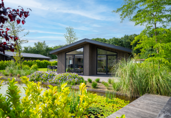 Lodge moderne Villa Waterzicht Luxe avec grandes baies vitrées, terrasse et vue sur un étang fleuri
