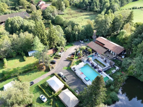 Vista aerea del campeggio Le Paradou con piscina, terrazze e aree verdi in Auvergne-Rhône-Alpes, Francia.