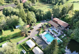 Vista aerea del campeggio Le Paradou con piscina, terrazze e aree verdi in Auvergne-Rhône-Alpes, Francia.