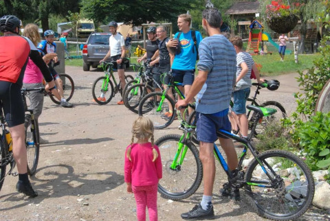Ciclisti e bambini si ritrovano al campeggio Le Paradou, parco vacanze in Auvergne-Rhône-Alpes, Francia.