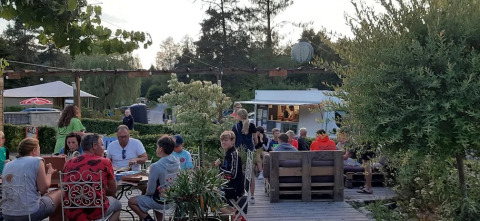 Cena all'aperto al tavolo al campeggio Le Paradou in Auvergne-Rhône-Alpes, Francia, durante la sera.