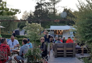 Cena all'aperto al tavolo al campeggio Le Paradou in Auvergne-Rhône-Alpes, Francia, durante la sera.