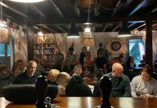 Un gruppo di persone si riunisce in un ambiente accogliente al campeggio Le Paradou, Auvergne-Rhône-Alpes, Francia.