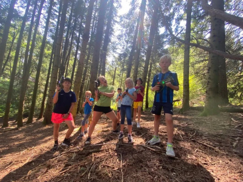 Bambini che giocano con pistole laser in una foresta al campeggio Le Paradou, Auvergne-Rhône-Alpes, Francia.