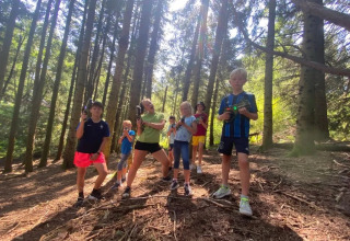 Bambini che giocano con pistole laser in una foresta al campeggio Le Paradou, Auvergne-Rhône-Alpes, Francia.