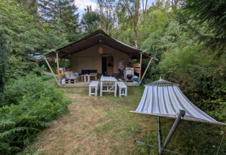 Campeggio Le Paradou in Alvernia-Rodano-Alpi, Francia, con tenda, tavoli da picnic e amaca nella natura.