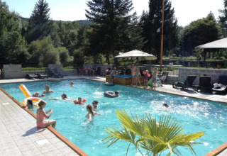 Bambini e adulti si godono una giornata di sole in piscina al campeggio Le Paradou in Alvernia-Rodano-Alpi, Francia.