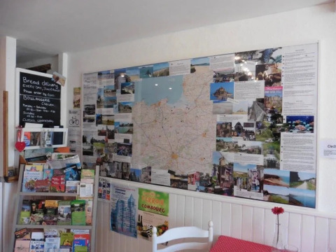 Angolo informativo con mappa, opuscoli e bacheca presso il campeggio Le Bois Coudrais in Bretagna, Francia.