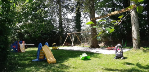 Parco giochi del campeggio Le Bois Coudrais in Bretagna, Francia, con scivoli, altalene e macchinine.