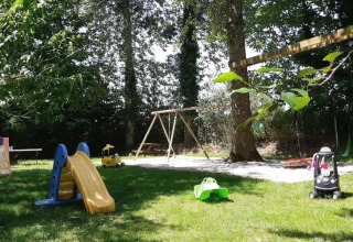 Parco giochi del campeggio Le Bois Coudrais in Bretagna, Francia, con scivoli, altalene e macchinine.