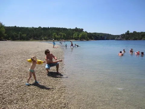 Mensen genieten van een zonnige dag aan het meer bij Camping Avelanède in Provence-Alpes-Côte d’Azur, Frankrijk.