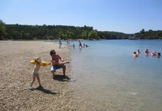 Menschen entspannen am Ufer eines Sees auf dem Campingplatz Avelanède in Provence-Alpes-Côte d’Azur, Frankreich.