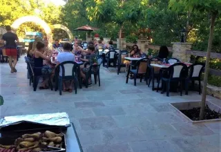 Gäste essen im Freien im Ferienpark Avelanède, Provence-Alpes-Côte d’Azur, Frankreich, an einem sonnigen Tag.