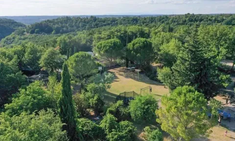 Vue aérienne du camping Avelanède en Provence-Alpes-Côte d’Azur, France, entouré de verdure et de forêts.