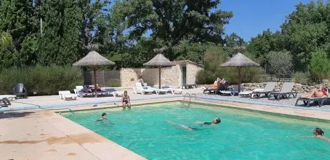 Buitenzwembad met gasten en ligbedden op Camping Avelanède in Provence-Alpes-Côte d’Azur, Frankrijk.