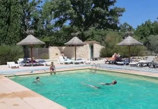 Udendørs swimmingpool med gæster og solsenge på Campsite Avelanède i Provence-Alpes-Côte d’Azur, Frankrig.