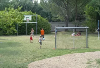 Kinderen spelen voetbal op een grasveld met basketbalpaal in een vakantiepark in Provence-Alpes-Côte d’Azur.