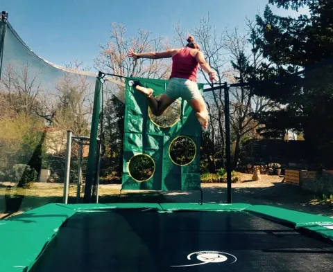 Persoon springt door een ring boven een trampoline op vakantiepark Avelanède in Zuid-Frankrijk.