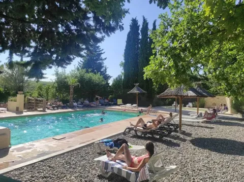 Vacacionistas descansando junto a la piscina en el Camping Avelanède en Provence-Alpes-Côte d’Azur, Francia.