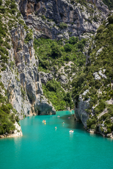 Personas en kayak en aguas turquesas rodeadas de acantilados en el camping Avelanède, Provenza, Francia.