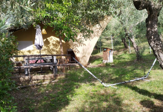 Rustig terras met hangmat bij Agricampeggio La Prugnola, vakantiepark tussen olijfbomen in Toscane, Italië.