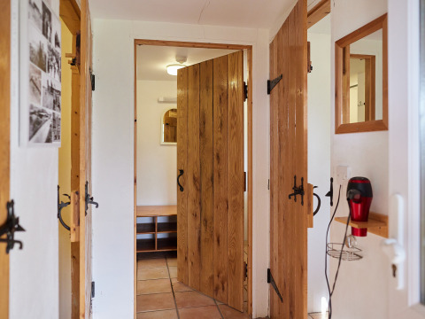 Gang met houten deuren, spiegels en een wandföhn bij BoerenBed Warren Farm vakantiepark in Zuidwest-Engeland.