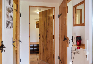 Couloir avec portes en bois, miroirs et sèche-cheveux mural à BoerenBed Warren Farm, parc de vacances au sud-ouest de l’Angleterre.