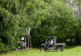 Mann fährt Geländefahrzeug auf einer Wiese bei BoerenBed Upper Shadymoor Farm, Wales, Vereinigtes Königreich.