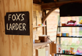Un cartello con la scritta 'FOX'S LARDER' su una parete di legno al BoerenBed Upper Shadymoor Farm in Galles.