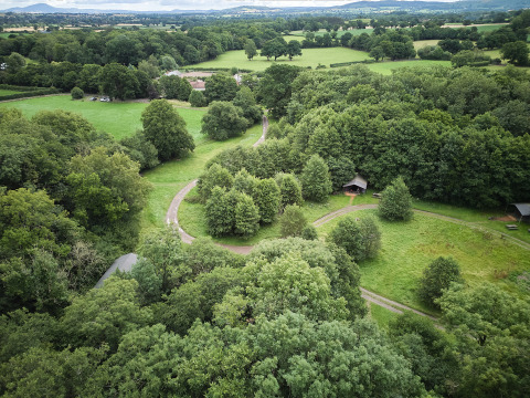 Vista aerea dei campi verdi, sentieri e alberi al BoerenBed Upper Shadymoor Farm, un parco vacanze in Galles, Regno Unito.