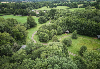 Luchtfoto van groene velden, kronkelende paden en bomen bij BoerenBed Upper Shadymoor Farm vakantiepark in Wales, VK.