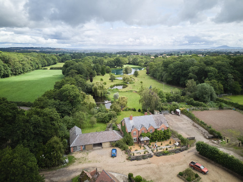 Luchtfoto van BoerenBed Upper Shadymoor Farm vakantiepark met groene velden en vijvers in Wales, Verenigd Koninkrijk.