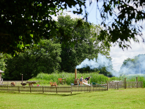 Famiglia si gode il tempo libero nella zona recintata di BoerenBed Upper Shadymoor Farm, Galles, con fumo.