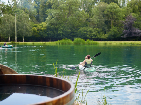 Persona in kayak sul lago a BoerenBed Upper Shadymoor Farm, circondata da alberi verdi nel Galles, Regno Unito.