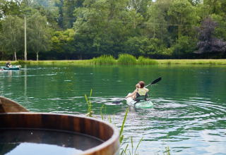 Persona in kayak sul lago a BoerenBed Upper Shadymoor Farm, circondata da alberi verdi nel Galles, Regno Unito.