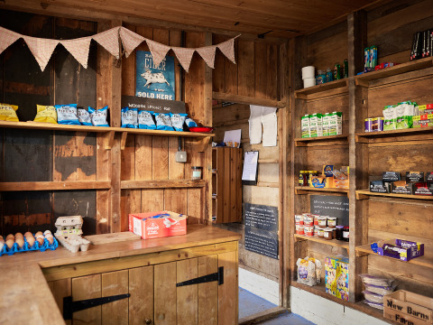 Lille landhandel med trævægge, lokale fødevarer, æg, snacks og hyldevarer på BoerenBed New Barn Farm.