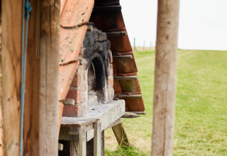 Udendørs brændefyret ovn ved BoerenBed New Barn Farm i det østlige England, omgivet af grønne marker.