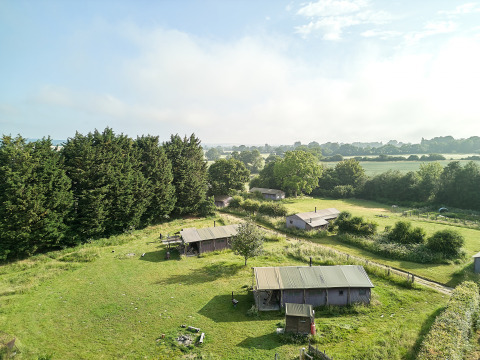 Vista del parque vacacional BoerenBed Manor Farm en el sureste de Inglaterra con campos y cabañas.