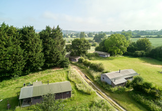 Luchtfoto van BoerenBed Manor Farm vakantiepark in Zuidoost-Engeland met hutten en groene weilanden.